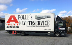 Sort flyttebil med stor hvid side og sort skrift, der reklamerer for Polle's Flytteservice og kontaktinformation.