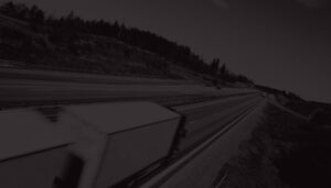 Lastbiler kører på motorvej på et sorthvid billede